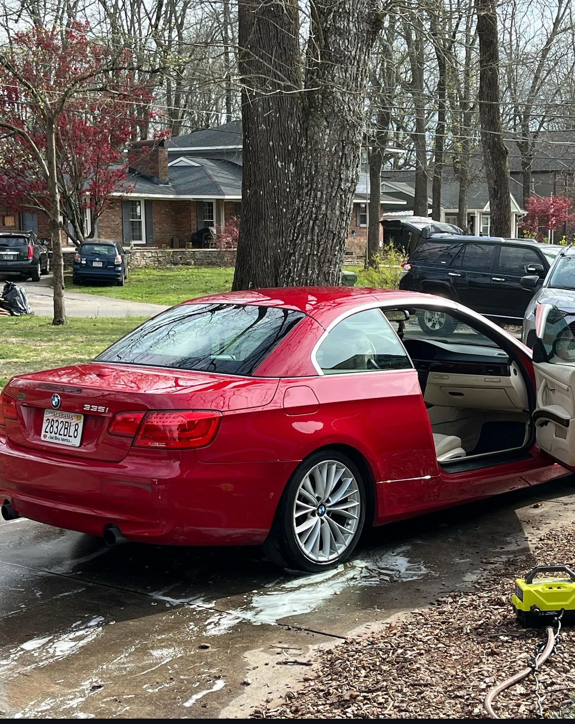 Red BMW 335i convertible being washed in the driveway